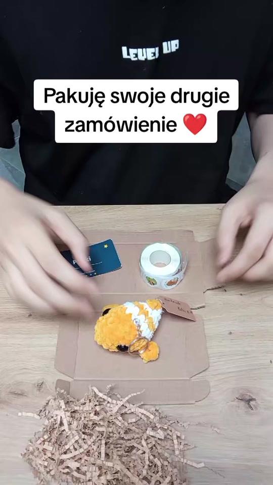 Bartosz pakuje ręcznie szydełkowaną maskotkę Pufkuj